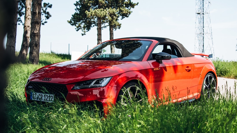 Aufnahme eines roten Sportwagens von Audi, der auf einem Rastplatz geparkt wurde - jetzt für eine Testfahrt mieten!